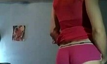 Remaja transseksual menggoda dengan tudung pantat dan zakar besar dalam gaun merah jambu